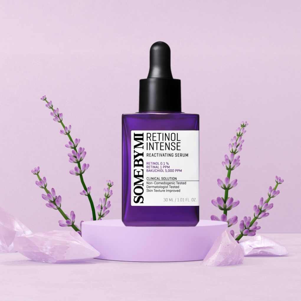 Bottle of some by mi retinol serum on stand amongst purple flowers - links to product
